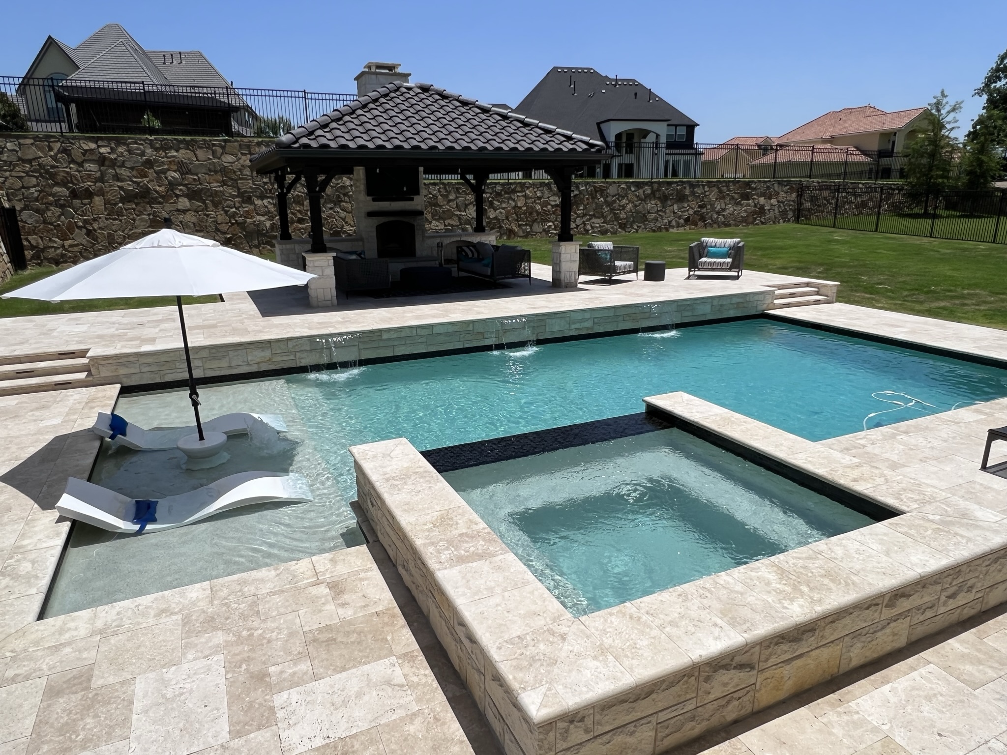 A completed Texas Traditions Outdoors pool and patio at dusk.